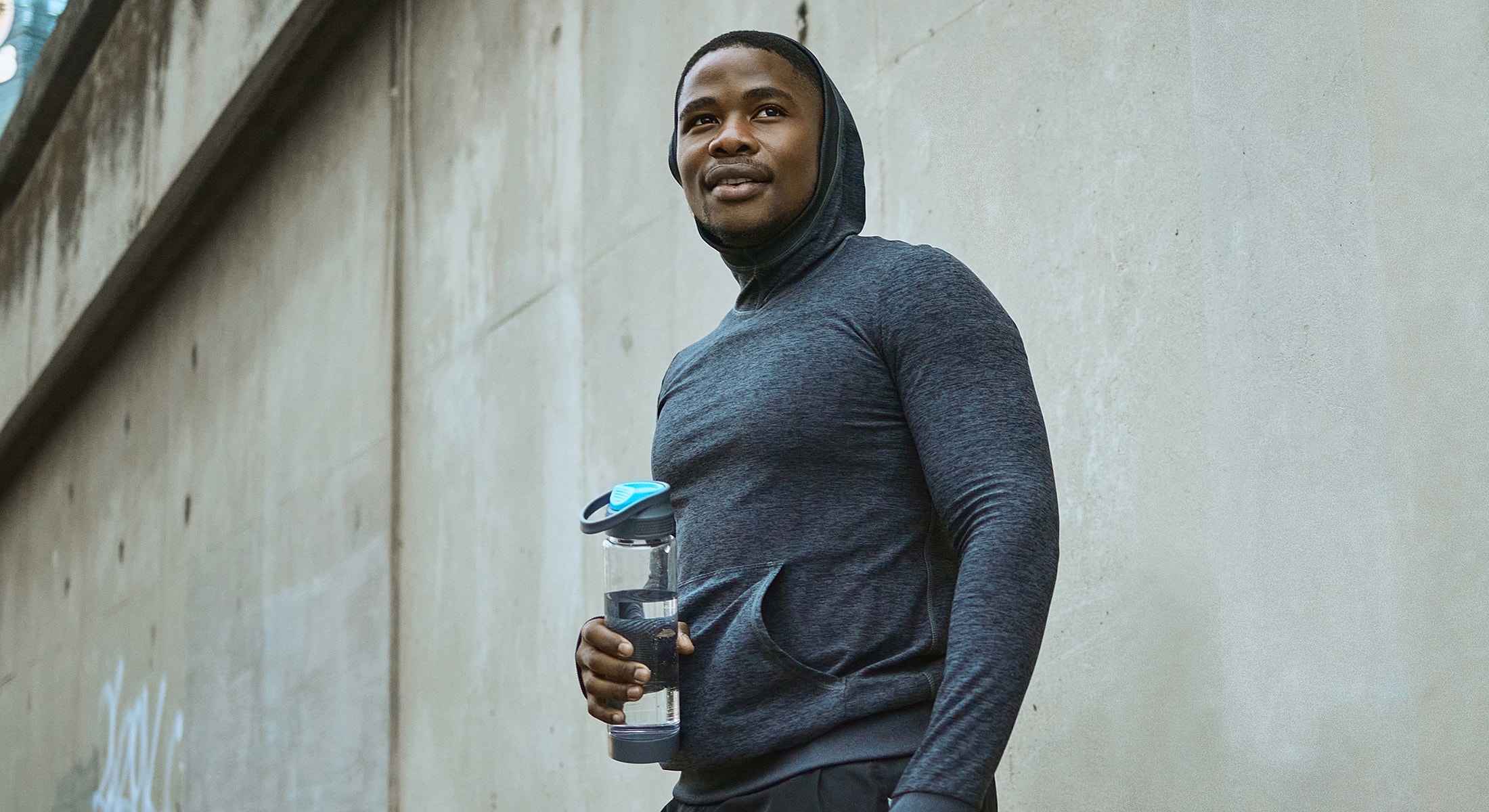 Disc replacement surgery patient model in sporty outfit holding water bottle.